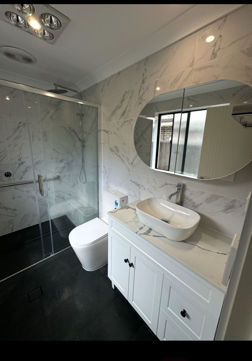 Marble-look bathroom renovation with vanity and shower screen by Endeavour Plumbing Group